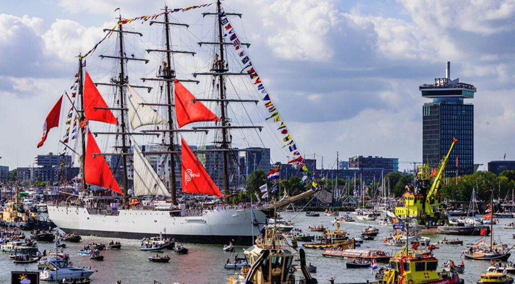 Hoge zeilschepen vertrekken uit Amsterdam tijdens jaarlijkse Sail-Out parade