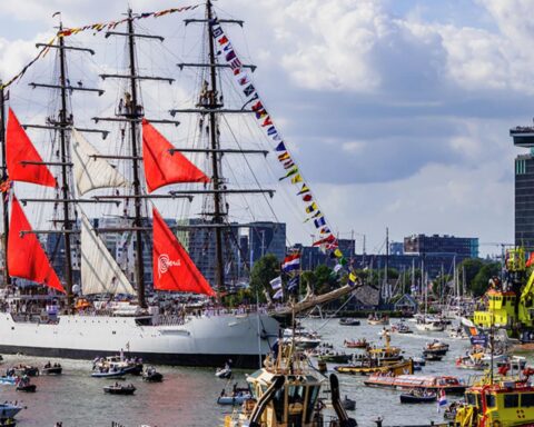 Hoge zeilschepen vertrekken uit Amsterdam tijdens jaarlijkse Sail-Out parade