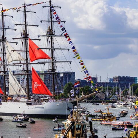 Hoge zeilschepen vertrekken uit Amsterdam tijdens jaarlijkse Sail-Out parade