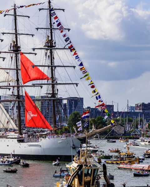 Hoge zeilschepen vertrekken uit Amsterdam tijdens jaarlijkse Sail-Out parade