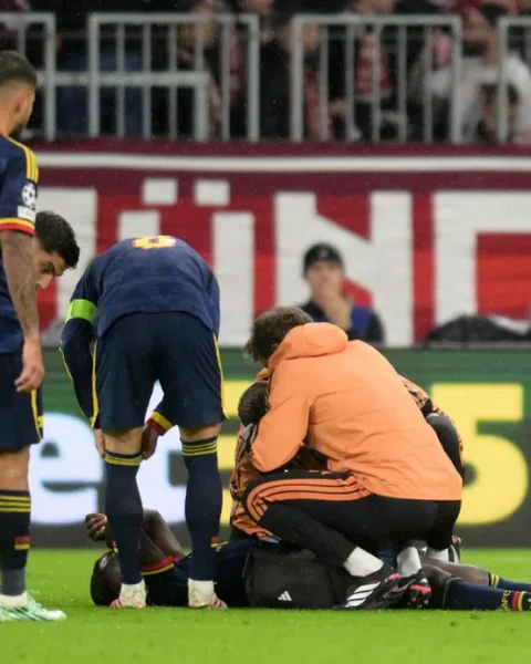 Arsenal-spelers en medische staf staan rond een geblesseerde speler op het veld tijdens een wedstrijd.