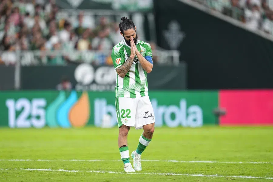 Isco staat met gevouwen handen op het veld in het groene-witte shirt van Real Betis.