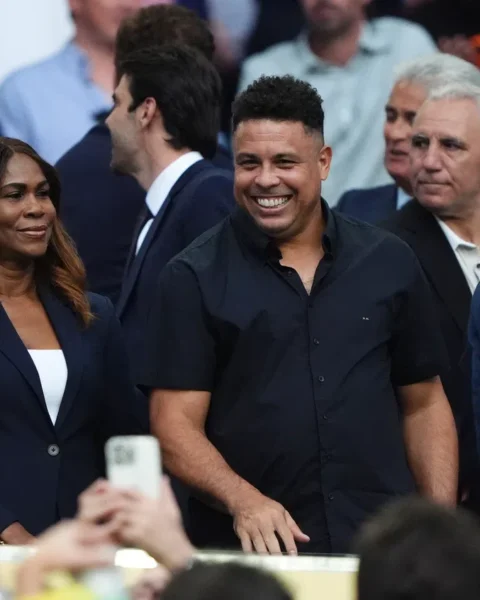 Ronaldo Nazário lacht tussen andere aanwezigen op een evenement.
