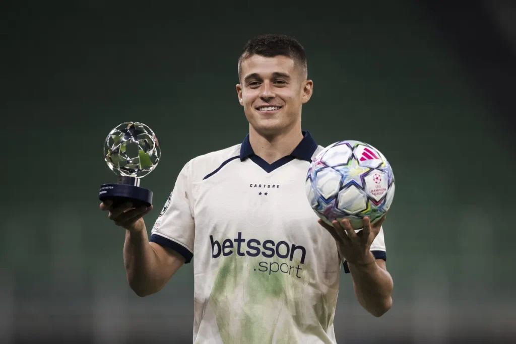 Nicolò Tresoldi houdt een trofee vast en een Champions League-bal.