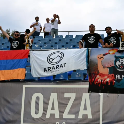 Supporters in a stadium hold banners and flags for Ararat Armenia.