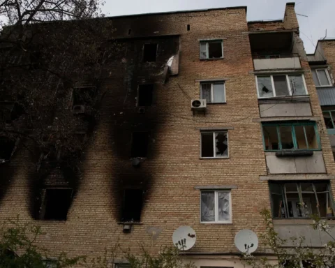 Beschadigd appartementsgebouw met verbrande gevel en kapotte ramen.