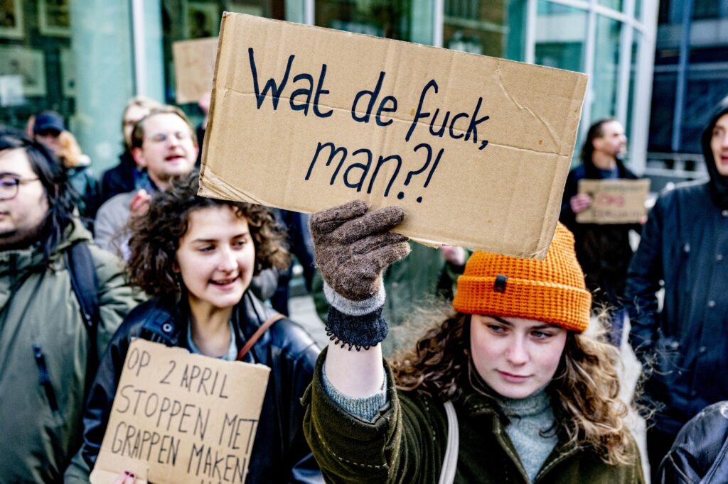 Demonstranten houden borden omhoog tijdens een protest op straat.