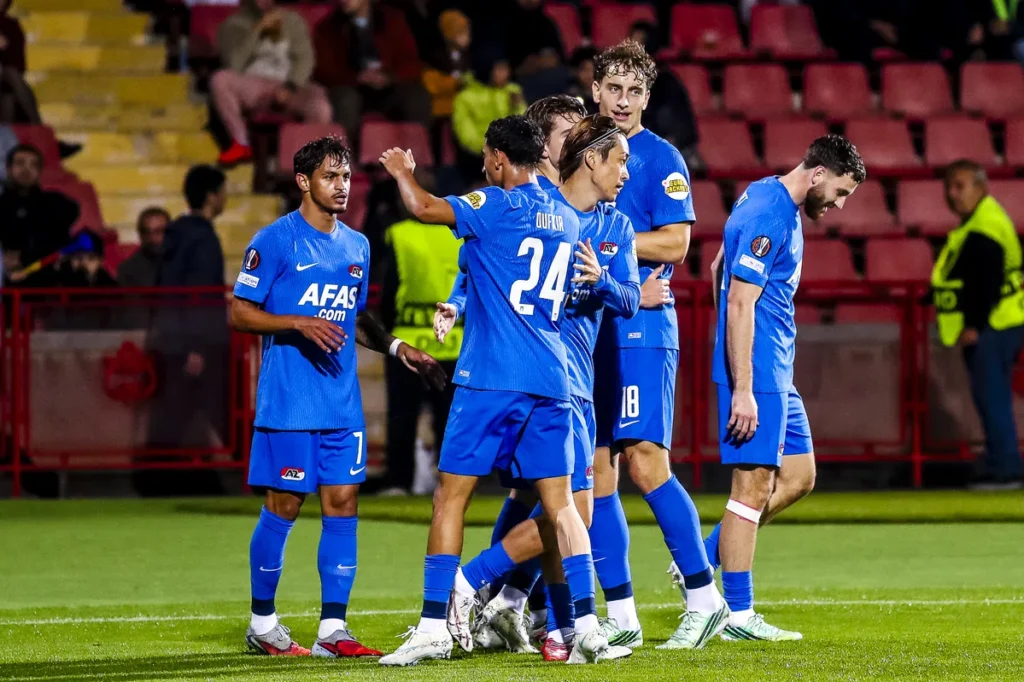 AZ-spelers staan samen op het veld tijdens de wedstrijd.