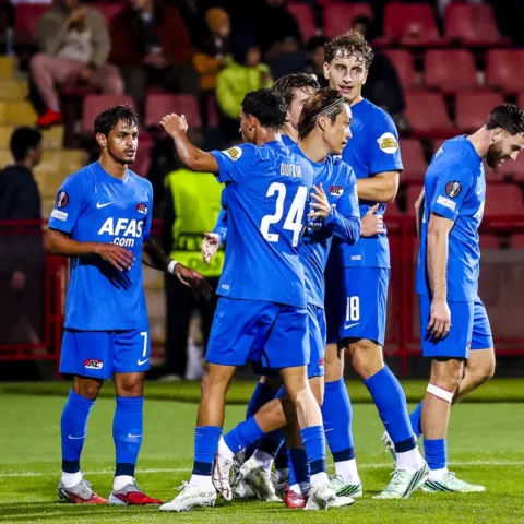 AZ-spelers staan samen op het veld tijdens de wedstrijd.
