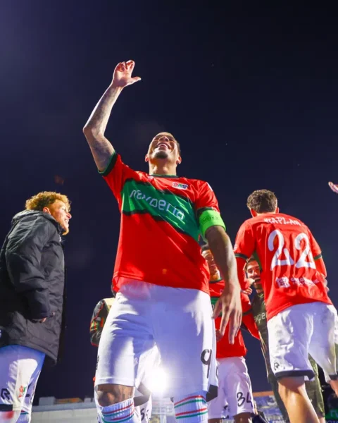 NEC-spelers en staf juichen op het veld na een wedstrijd.