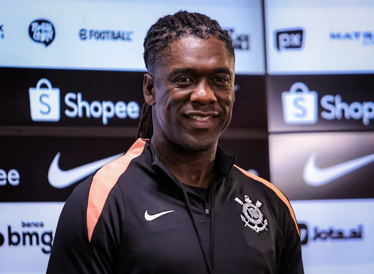 Een Corinthians-figure poseert voor een sponsorwand met clublogo en merklogo’s.