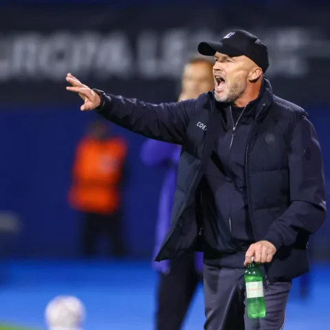Dick Schreuder geeft aanwijzingen langs de lijn tijdens een voetbalwedstrijd.