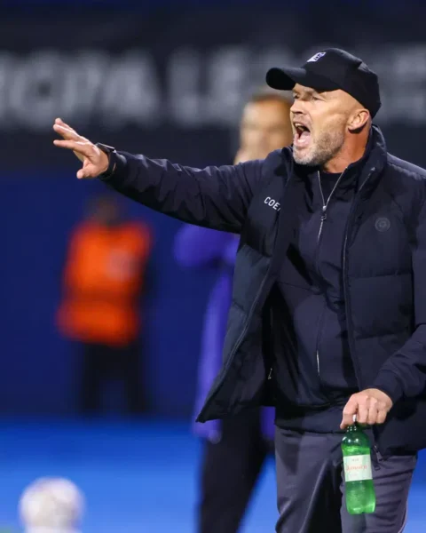 Dick Schreuder geeft aanwijzingen langs de lijn tijdens een voetbalwedstrijd.