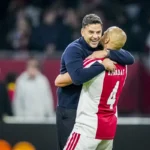 Míchel omhelst een Ajax-speler langs het veld.