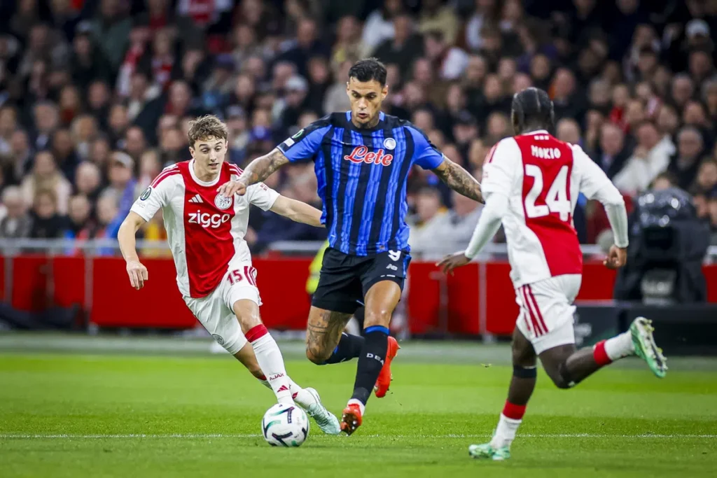 Ajax- en Atalanta-spelers in duel om de bal tijdens een voetbalwedstrijd.