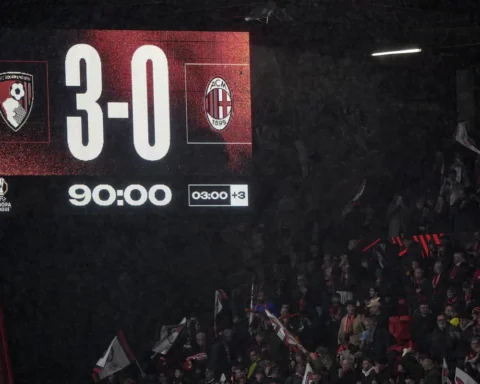 Scoreboard in een stadion toont Bournemouth 3-0 AC Milan, met supporters op de tribunes.