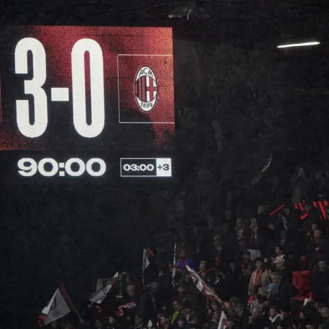 Scoreboard in een stadion toont Bournemouth 3-0 AC Milan, met supporters op de tribunes.