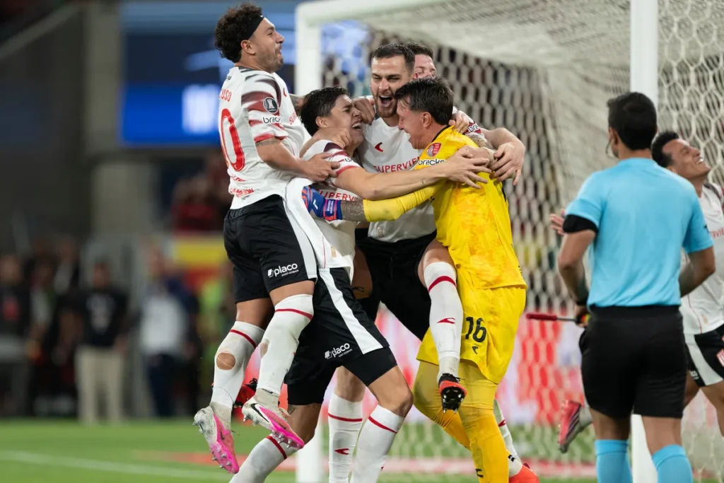 Spelers en de doelman van Estudiantes juichen en omhelzen elkaar naast het doel.