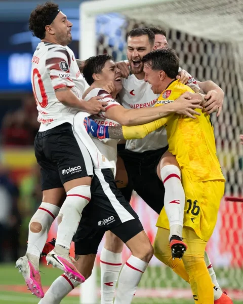 Spelers en de doelman van Estudiantes juichen en omhelzen elkaar naast het doel.