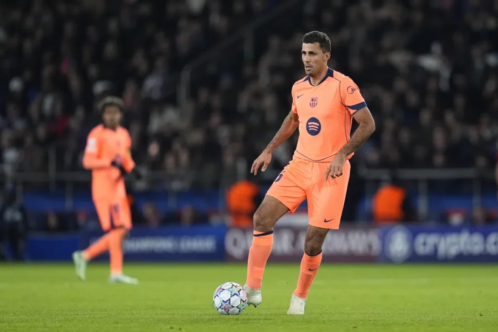 Rodri in een feloranje Barcelona-tenue op het veld tijdens een voetbalwedstrijd.