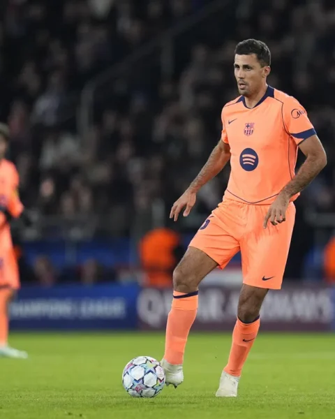 Rodri in een feloranje Barcelona-tenue op het veld tijdens een voetbalwedstrijd.