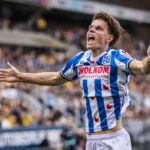 Oliver Braude in het SC Heerenveen-shirt juicht op het veld met uitgestrekte armen.