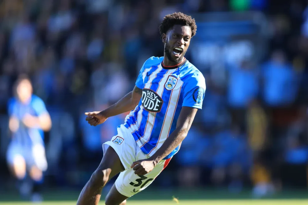 Huddersfield Town speler juicht op het veld in een competitiewedstrijd.
