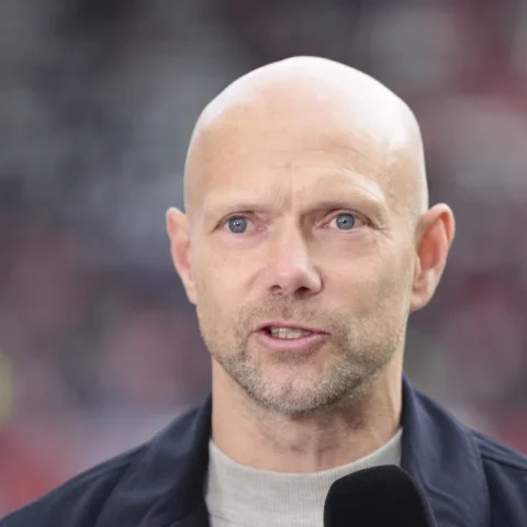 Dennis van der Ree spreekt voor een stadionachtergrond.