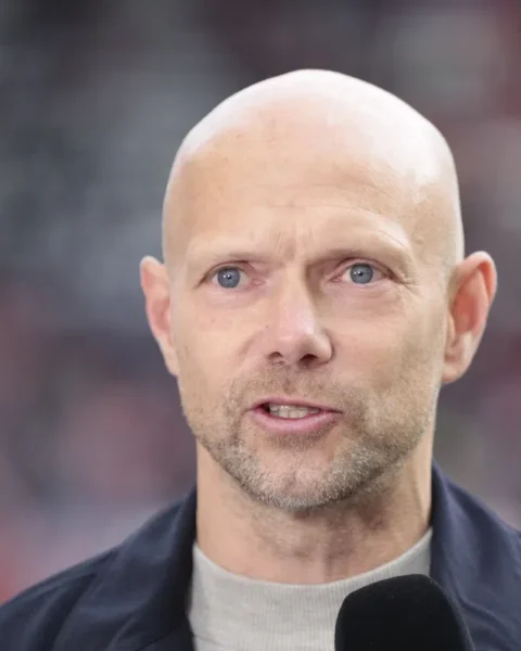 Dennis van der Ree spreekt voor een stadionachtergrond.