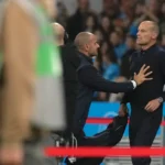 Massimiliano Allegri staat langs de zijlijn tijdens een voetbalwedstrijd terwijl een official hem aanspreekt.