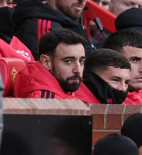 Manchester United-spelers op de bank tijdens een wedstrijd.