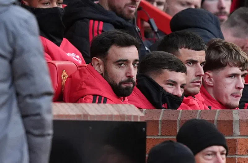 Manchester United-spelers op de bank tijdens een wedstrijd.