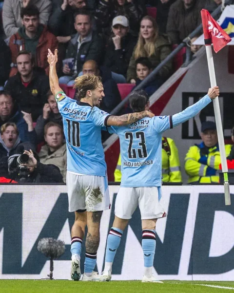 Feyenoord-spelers vieren een doelpunt bij de cornervlag in het stadion.