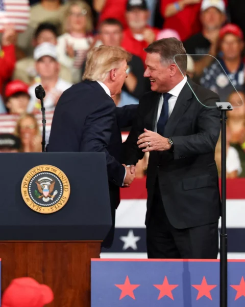 Donald Trump schudt handen op een politieke rally voor een publiek.