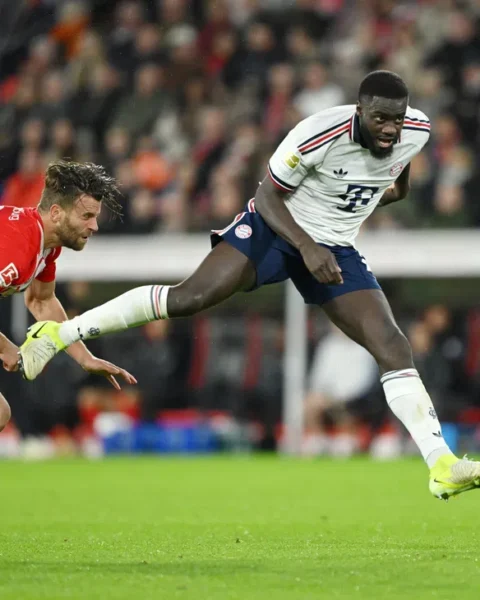 SC Freiburg- en Bayern München-spelers in duel om de bal tijdens een Bundesliga-wedstrijd.