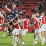 Spelers van AZ en FC Twente springen en duelleren om de bal tijdens een Eredivisie-wedstrijd.