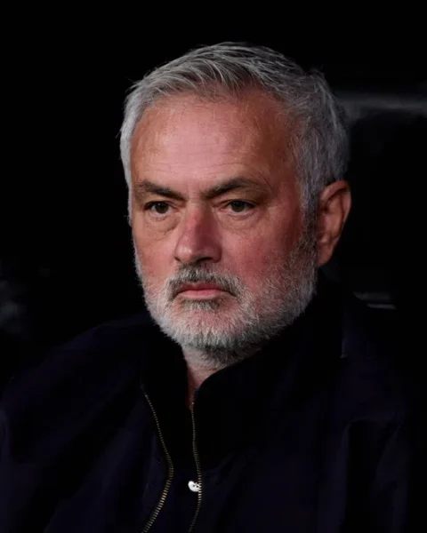 José Mourinho zit op de bank en kijkt ernstig voor zich uit.