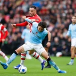 Voetballers van Feyenoord en PSV in duel om de bal op het veld.