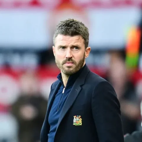 Michael Carrick staat langs de zijlijn in een Manchester United-jasje.