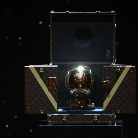 De Gouden Bal-trofee in een open presentatiekoffer op een donkere achtergrond.