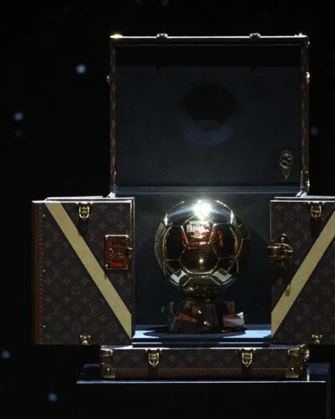 De Gouden Bal-trofee in een open presentatiekoffer op een donkere achtergrond.