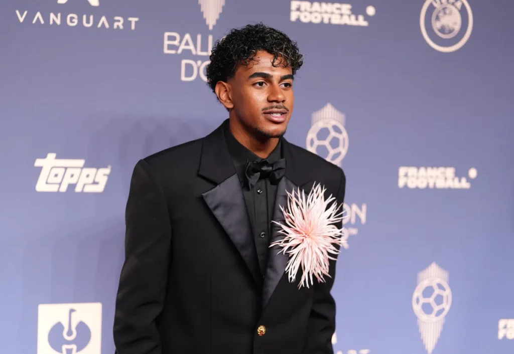 Lamine Yamal poseert op de rode loper bij het Ballon d’Or-gala in een zwart pak.