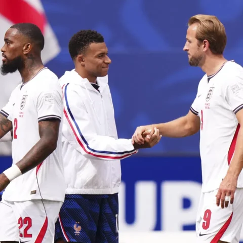 Spelers van Engeland en Frankrijk begroeten elkaar op het veld tijdens een voetbalwedstrijd.