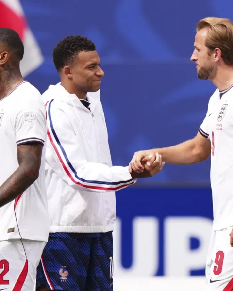 Spelers van Engeland en Frankrijk begroeten elkaar op het veld tijdens een voetbalwedstrijd.