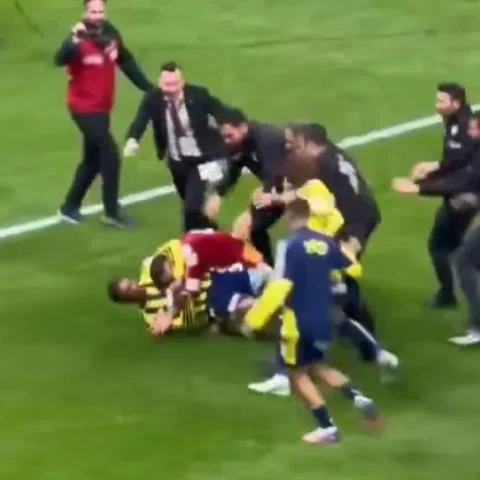 Spelers en staf ruziën en worstelen op het veld na de wedstrijd.