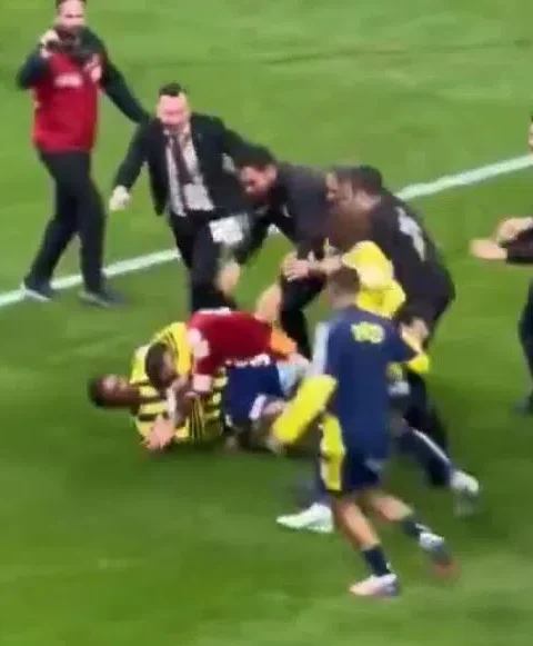 Spelers en staf ruziën en worstelen op het veld na de wedstrijd.