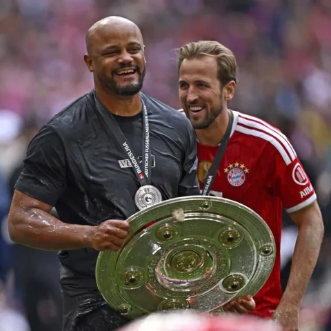 Vincent Kompany en Harry Kane lachen samen met de Duitse landstitel in handen.