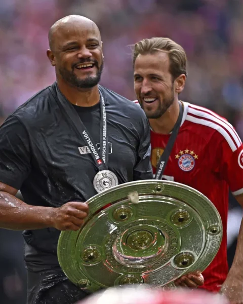 Vincent Kompany en Harry Kane lachen samen met de Duitse landstitel in handen.