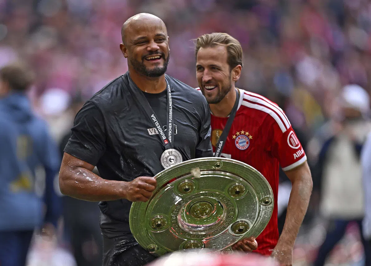 Vincent Kompany en Harry Kane lachen samen met de Duitse landstitel in handen.