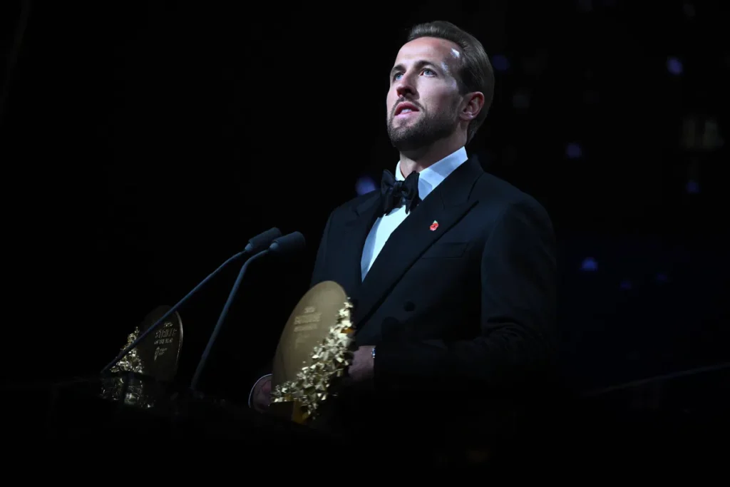 Harry Kane in een zwart smokingpak bij een podium tijdens een prijsuitreiking.